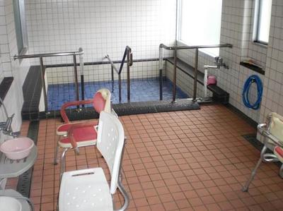 介護用の浴室。手すり付きの浴槽と機械浴槽が設置された施設の入浴設備